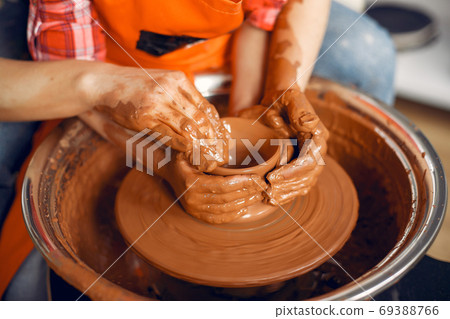People making a vaze from a clay on a pottery's machine 69388766