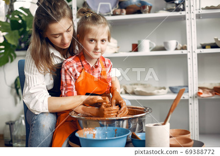 People making a vaze from a clay on a pottery's machine People making a vaze from a clay on a pottery's machine 69388772