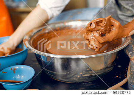 Girl making a vaze from a clay on a pottery's machine 69388775