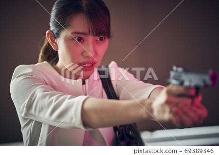 A woman with a gun 69389346
