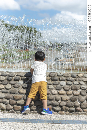 男孩碰噴泉的水 69391042