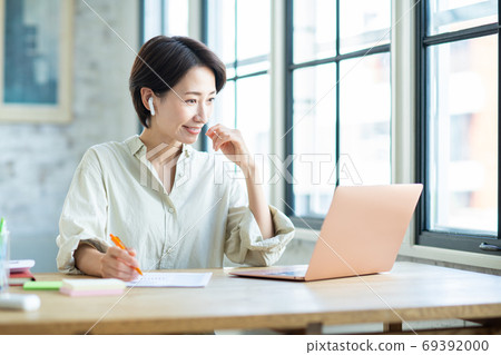 Middle-aged woman teleworking Middle-aged woman teleworking 69392000