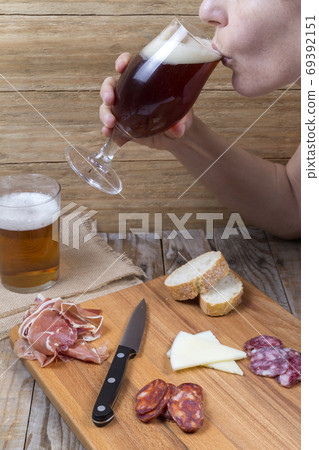 Woman drinking from a glass of beer 69392151