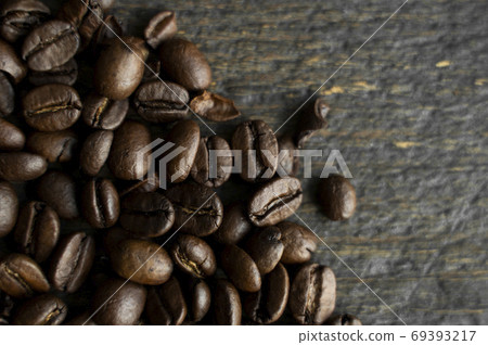 Roasted arabica coffee beans scattered on a wooden table. Fresh coffee beans. 69393217