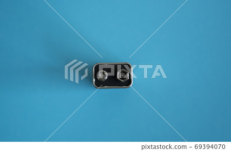 High voltage battery on a blue background. Silver Volt battery. 9V Advanced Lithium Batteries. High voltage battery on a blue background. Silver Volt battery. 9V Advanced Lithium Batteries. 69394070