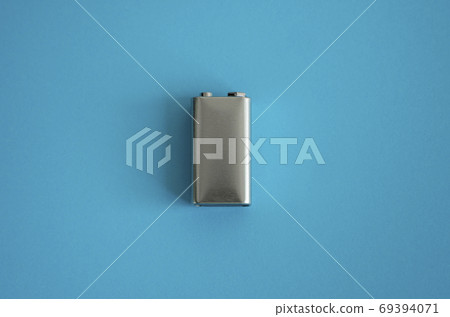 High voltage battery on a blue background. Silver Volt battery. 9V Advanced Lithium Batteries. High voltage battery on a blue background. Silver Volt battery. 9V Advanced Lithium Batteries. 69394071