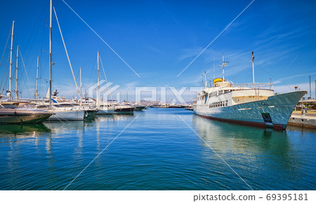 Boats and yachts anchored or moored in Athens marina and by its promenade in Glyfada on a bright summer day. Athens, Greece 69395181