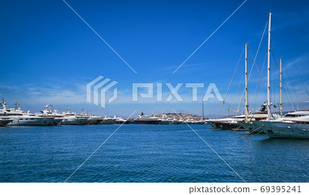 Boats and yachts anchored or moored in a marina and by its promenade on a bright summer day. Beautiful seascape. Leisure, cruise, vacation. Boats and yachts anchored or moored in a marina and by its promenade on a bright summer day. Beautiful seascape. Leisure, cruise, vacation. 69395241