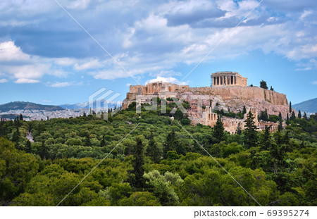 View of Acropolis hill and theater of Odeon in Athens, Greece from the hill of Philoppapos or Muses in summer daylight with great clouds in blue sky. 69395274