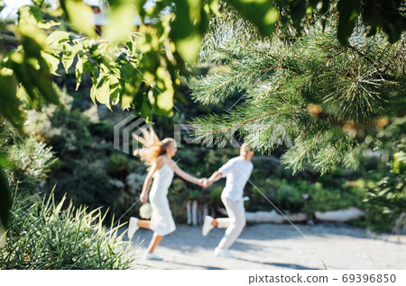 Happy young couple walking together in a green park 69396850