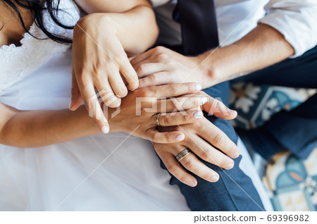 close-up portrait of the bride and groom. They hug their arms. Wedding rings on their hands close-up portrait of the bride and groom. They hug their arms. Wedding rings on their hands 69396982
