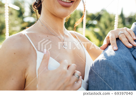 Close-up portrait of a bride and groom standing on the city street and lovely hugging Close-up portrait of a bride and groom standing on the city street and lovely hugging 69397040