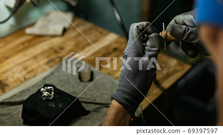 close-up. The jeweler makes a silver ring 69397597