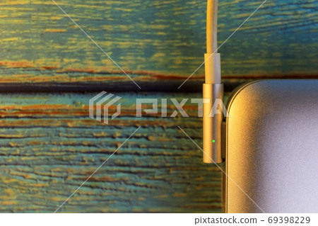 Top view close up laptop with electric charger cable on blue co Top view close up laptop with electric charger cable on blue co 69398229