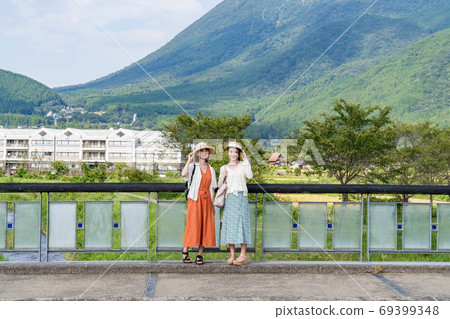 A young woman and a friend taking a commemorative photo on a Yufuin girls' trip [September] 69399348