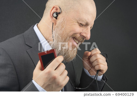 bearded business man likes to listen to his favorite music at ho 69400129