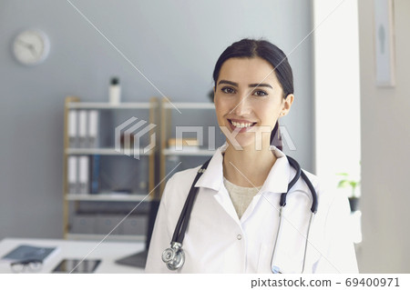 Doctor looking at camera in medical office, having online consultation with patient Doctor looking at camera in medical office, having online consultation with patient 69400971