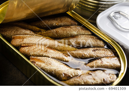 Canned smoked fish sprats in just opened tin can. Non-perishable 69401309