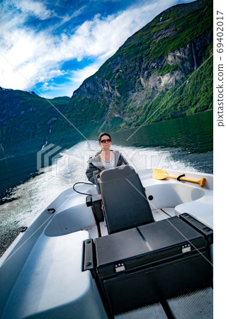 Woman driving a motor boat Woman driving a motor boat 69402017