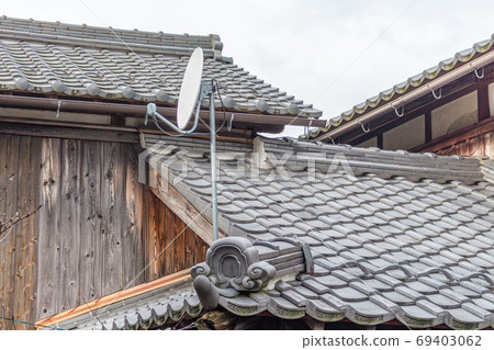Satellite dish on old traditional houses. Kumagawa, a small village on the historic trading route from Kyoto to Fukui, Japan. Satellite dish on old traditional houses. Kumagawa, a small village on the historic trading route from Kyoto to Fukui, Japan. 69403062