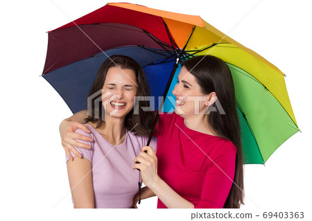 Two laughing young women with rainbow umbrella Two laughing young women with rainbow umbrella 69403363