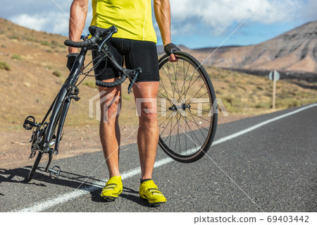 Bike repair cyclist man on side of road repair road bicycle problem with wheel. Cycling outdoor athlete biker biking with cycle 69403442