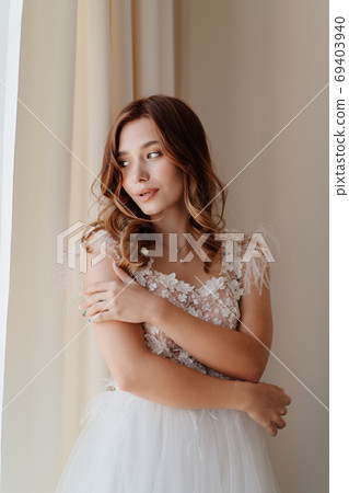 bride in dress with feathers hugging his shoulders 69403940