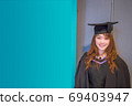 Graduation day, portrait of smiling girl student in a graduation cap and gown. Postcard / Poster 69403947