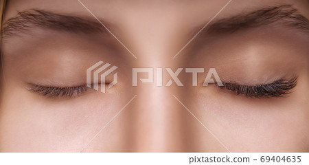 Eyelash Extension Procedure. Woman Eye with Long Eyelashes. Close up, selective focus. Eyelash Extension Procedure. Woman Eye with Long Eyelashes. Close up, selective focus. 69404635