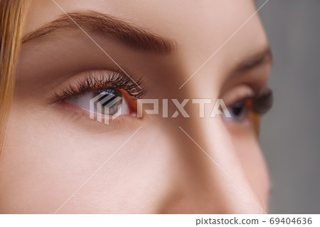 Eyelash Extension Procedure. Woman Eye with Long Eyelashes. Close up, selective focus. Eyelash Extension Procedure. Woman Eye with Long Eyelashes. Close up, selective focus. 69404636