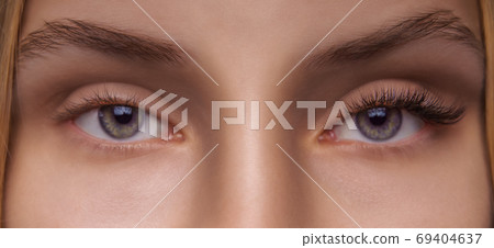 Eyelash Extension Procedure. Woman Eye with Long Eyelashes. Close up, selective focus. Eyelash Extension Procedure. Woman Eye with Long Eyelashes. Close up, selective focus. 69404637