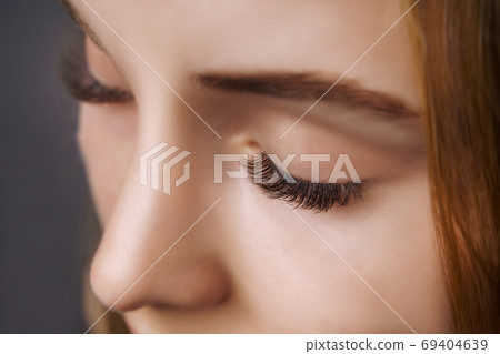 Eyelash Extension Procedure. Woman Eye with Long Eyelashes. Close up, selective focus. Eyelash Extension Procedure. Woman Eye with Long Eyelashes. Close up, selective focus. 69404639