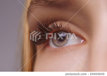 Eyelash Extension Procedure. Woman Eye with Long Eyelashes. Close up, selective focus. Eyelash Extension Procedure. Woman Eye with Long Eyelashes. Close up, selective focus. 69404640