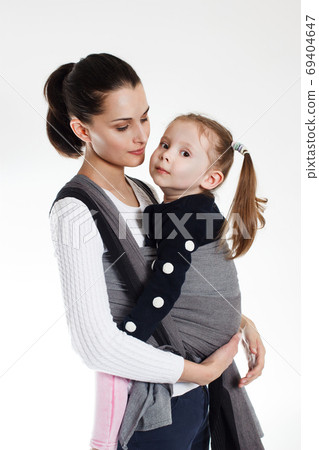A toddler girl in front cross carry wrap in woven baby carrier A toddler girl in front cross carry wrap in woven baby carrier 69404647