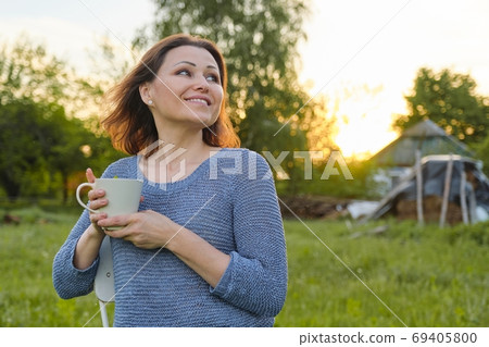 Resting mature woman with cup of tea, female in nature 69405800
