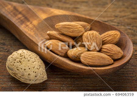 almond nuts on a wooden spoon almond nuts on a wooden spoon 69406359