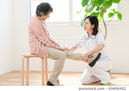 Caregiver assisting in rehabilitation 69406482