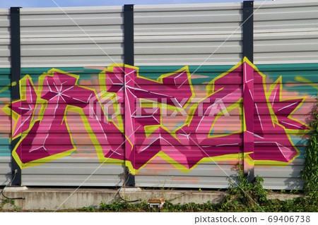Purple,yellow and pink graffiti on a noise barrier wall Purple,yellow and pink graffiti on a noise barrier wall 69406738