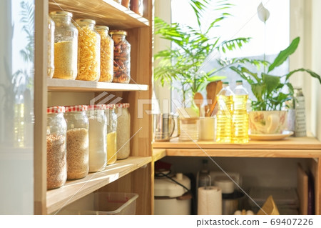 Kitchen utensils, sunflower oil on wooden table in pantry, food storage at home Kitchen utensils, sunflower oil on wooden table in pantry, food storage at home 69407226