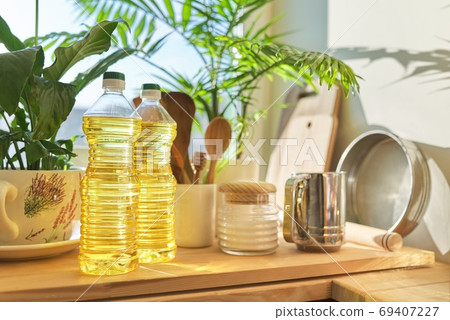 Kitchen utensils, sunflower oil on wooden table in pantry Kitchen utensils, sunflower oil on wooden table in pantry 69407227