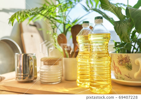 Kitchen utensils, sunflower oil on wooden table in pantry Kitchen utensils, sunflower oil on wooden table in pantry 69407228