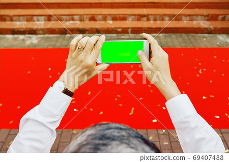 Man's hands shooting with phone empty green screen red carpet Man's hands shooting with phone empty green screen red carpet 69407488