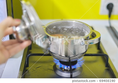 Saucepan with boiling eggs on a gas stove Saucepan with boiling eggs on a gas stove 69408190
