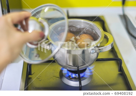 Saucepan with boiling eggs on a gas stove 69408192