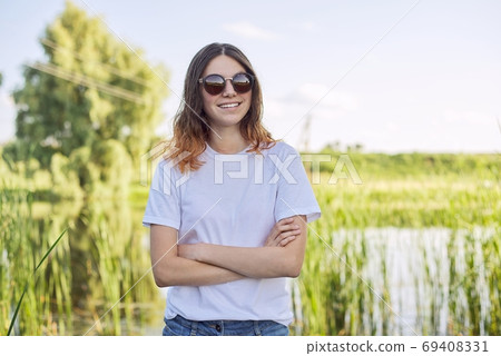 Portrait of smiling teenage girl in sunglasses on nature Portrait of smiling teenage girl in sunglasses on nature 69408331