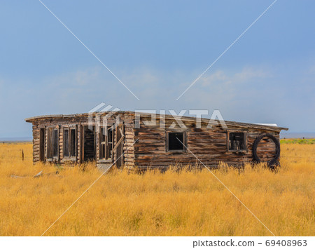 A low profile abandoned barn falling apart in rural Colorado A low profile abandoned barn falling apart in rural Colorado 69408963