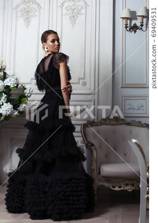 young pretty lady in black lace fashion style dress posing in rich interior of royal hotel room, luxury lifestyle people concept young pretty lady in black lace fashion style dress posing in rich interior of royal hotel room, luxury lifestyle people concept 69409531