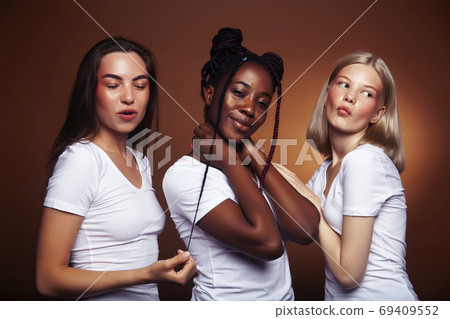 young pretty asian, caucasian, afro woman posing cheerful together on brown background, lifestyle diverse nationality people concept young pretty asian, caucasian, afro woman posing cheerful together on brown background, lifestyle diverse nationality people concept 69409552