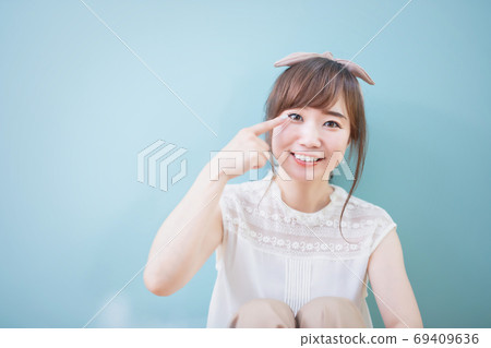 A woman pointing at her eyes A woman pointing at her eyes 69409636
