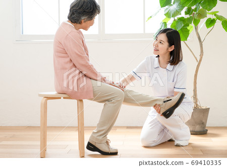 Caregiver assisting in rehabilitation 69410335